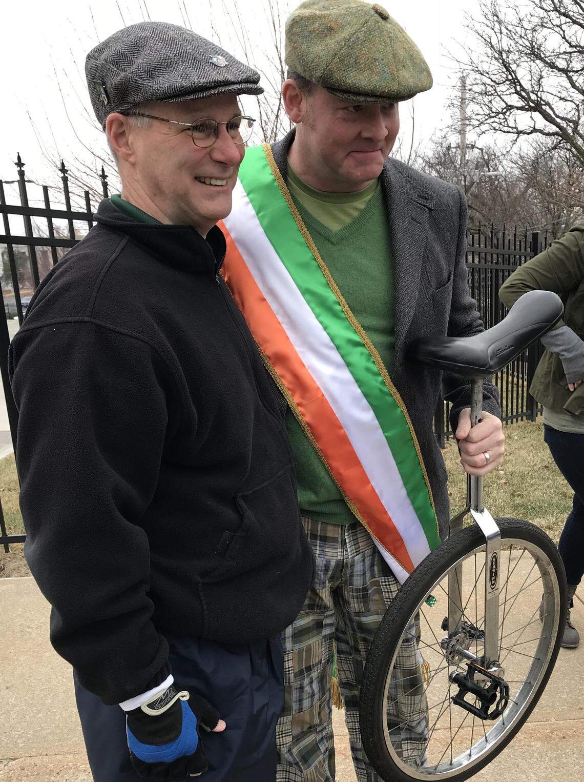 Comedian and actor David Koechner poses with a unicyclist before he took the role of grand marshal of the Kansas City St. Patrick's Day parade.