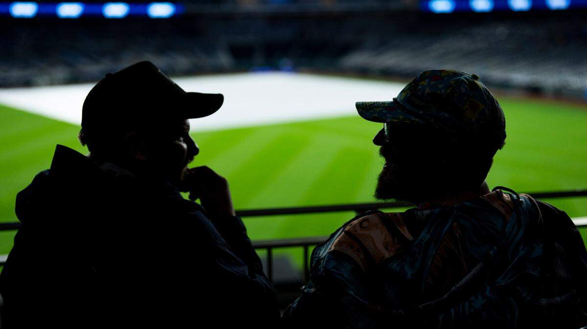 Fans wait during a rain delay prior to a game between the Colorado Rockies and the Kansas City Royals at Kauffman Stadium.