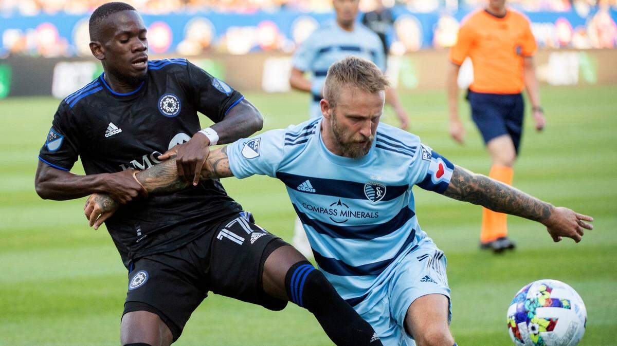 Sporting Kansas City’s Johnny Russell, right, works to keep CF Montreal’s Jojea Kwizera at bay during Saturday evening’s match in Montreal.
