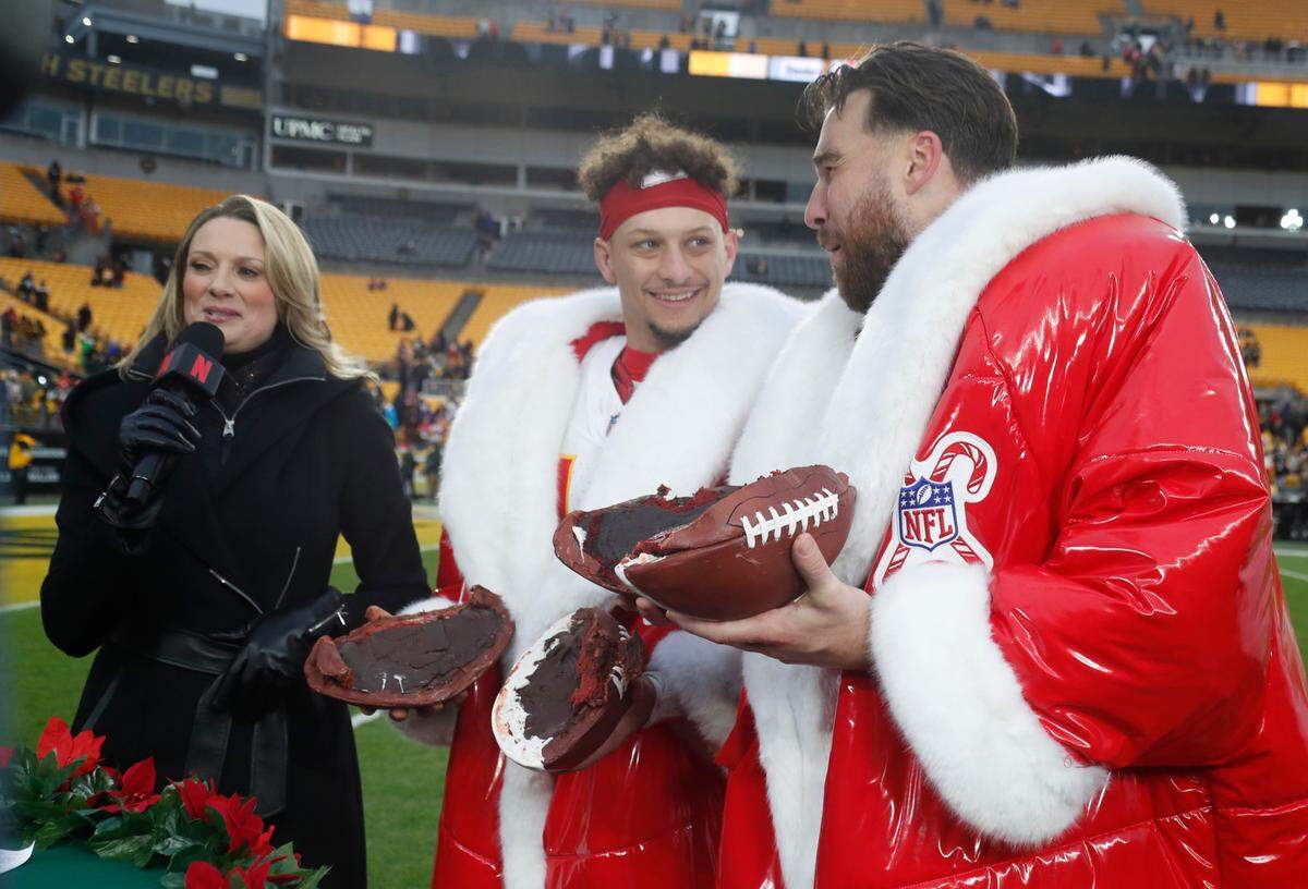 Kansas City Chiefs quarterback Patrick Mahomes (middle) and tight end Travis Kelce (right) wear special players-of-the-game coats (and check out their edible postgame footballs, all provided by Netflix) after beating the Steelers at Acrisure Stadium in Pittsburgh, Pennsylvania on Wednesday, Dec. 25, 2024.