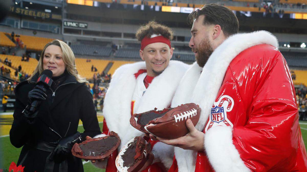Kansas City Chiefs quarterback Patrick Mahomes (middle) and tight end Travis Kelce (right) wear special players-of-the-game coats (and check out their edible postgame footballs, all provided by Netflix) after beating the Steelers at Acrisure Stadium in Pittsburgh, Pennsylvania on Wednesday, Dec. 25, 2024.
