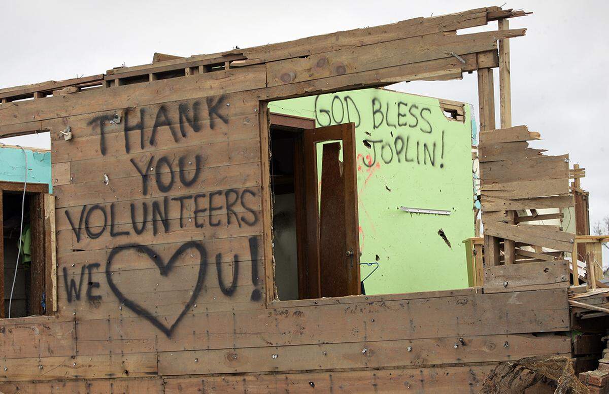 Saying that they like the community and the good people, Tim and Stacey Bartow are planning to stay in Joplin. Tim painted several signs on the remains of his home to thank volunteers and send out a message of hope to fellow residents. 05262011 KEITH MYERS/The Kansas City Star
