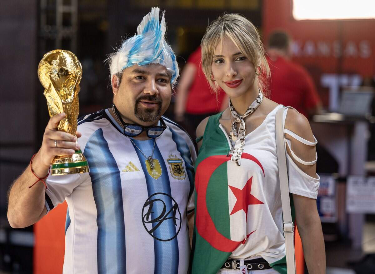 Fan from Argentina has his photo taken with an Algerian fan at Union Station on Monday. The two countries will face off on Tuesday at Kansas City Stadium.