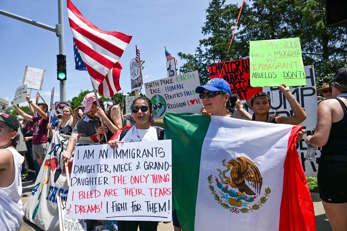 The Trump administration’s policies on immigration were the subject of many signs during the “No Kings” rally Saturday, June 14, 2025, at Mill Creek Park in Kansas City.
