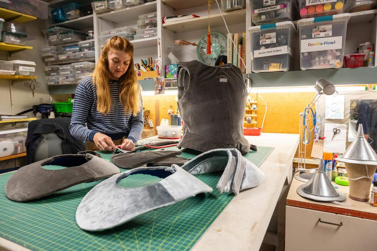 Joey Gee measures fabrics for the Tin Man character in her craft room at the Spencer Theatre.