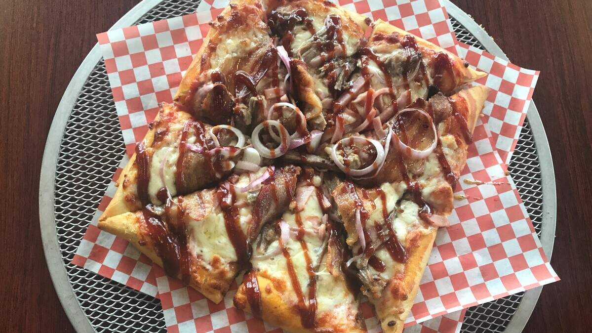 Crust Plus pizza's The Q, which has pulled pork, bacon, ham, pickled red onions and Q39 barbecue sauce.