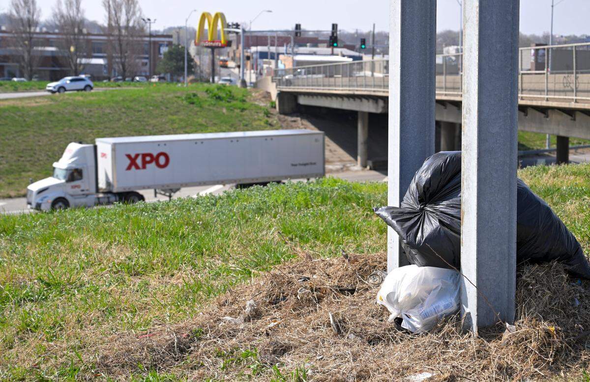 Bags of trash awaiting pickup from the city sit near the Van Brunt Boulevard exit just off of Interstate 70 on April 4 in Kansas City.