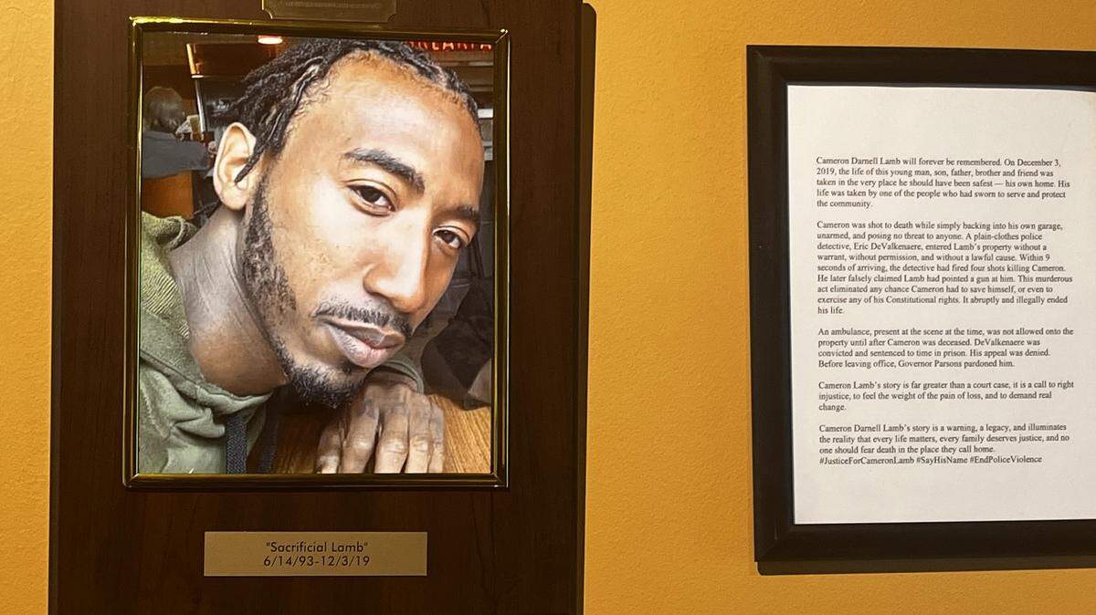 A picture of Cameron Lamb, a 26-year-old Black man gunned down by a Kansas City police detective, hangs, at the Black Archives of Mid-America over an exhibit about Lamb’s killing and the subsequent trial.