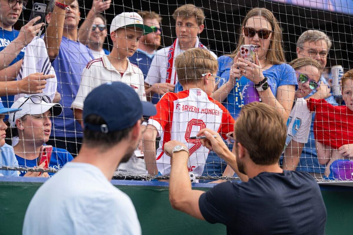 A fan gets a jersey signed by England soccer star Harry Kane before the Royals’ game against the St. Louis Cardinals at Kauffman Stadium in Kansas City on Thursday, June 18, 2026.