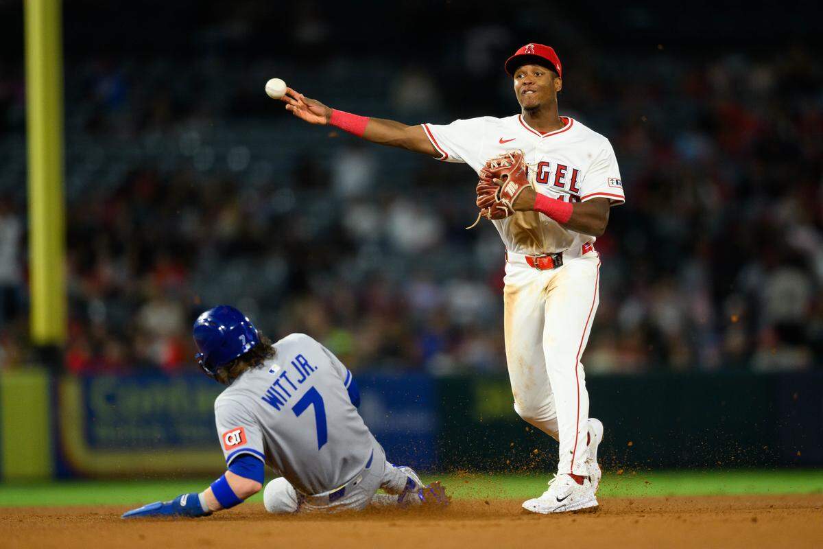 Sep 25, 2025; Anaheim, California, USA; Los Angeles Angels shortstop Denzer Guzman (13) throws to first after forcing out Kansas City Royals shortstop Bobby Witt Jr. (7) during the third inning at Angel Stadium. Mandatory Credit: William Liang-Imagn Images