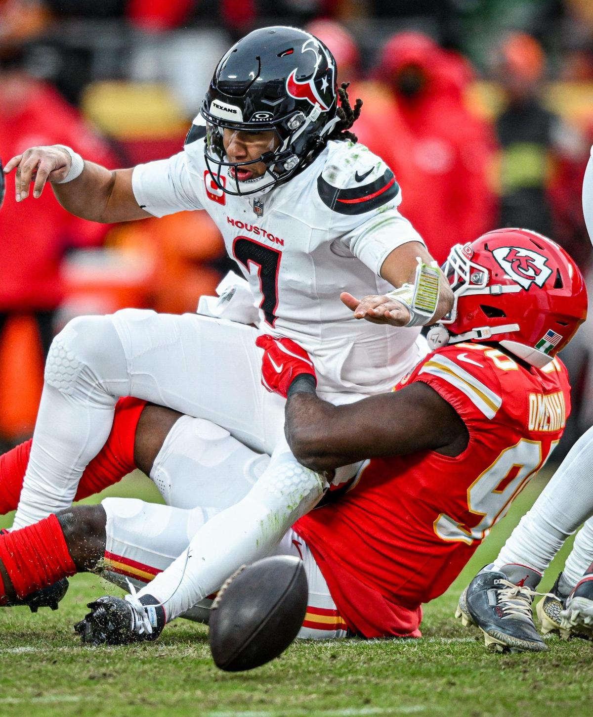 Kansas City Chiefs defensive end Charles Omenihu (90) knocks the ball out of the hand of Houston Texans quarterback C.J. Stroud (7) as he pulls him down in the second quarter during the AFC Divisional Round playoff game on Saturday, Jan. 18, 2025, at GEHA Field at Arrowhead Stadium.