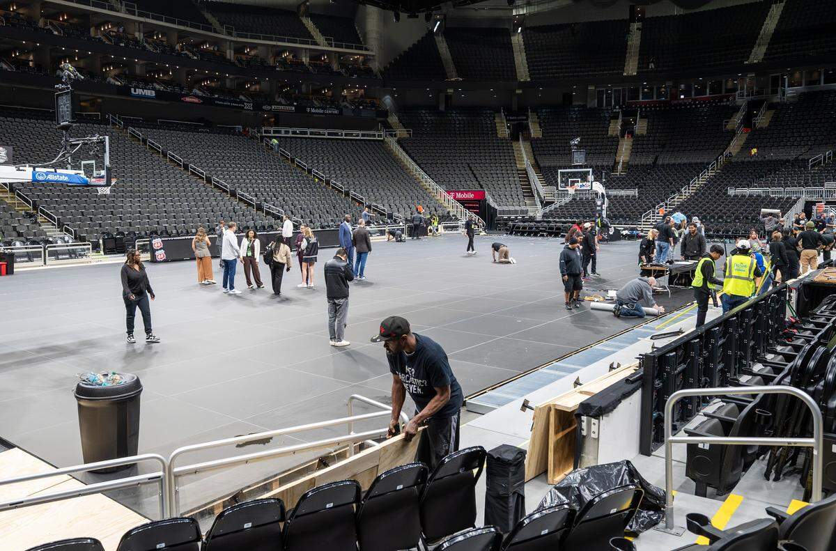 Crews dismantle the Big 12 Men's Basketball Tournament LED basketball court during the midnight hours at T-Mobile Center on Friday, March 13, 2026, in Kansas City.