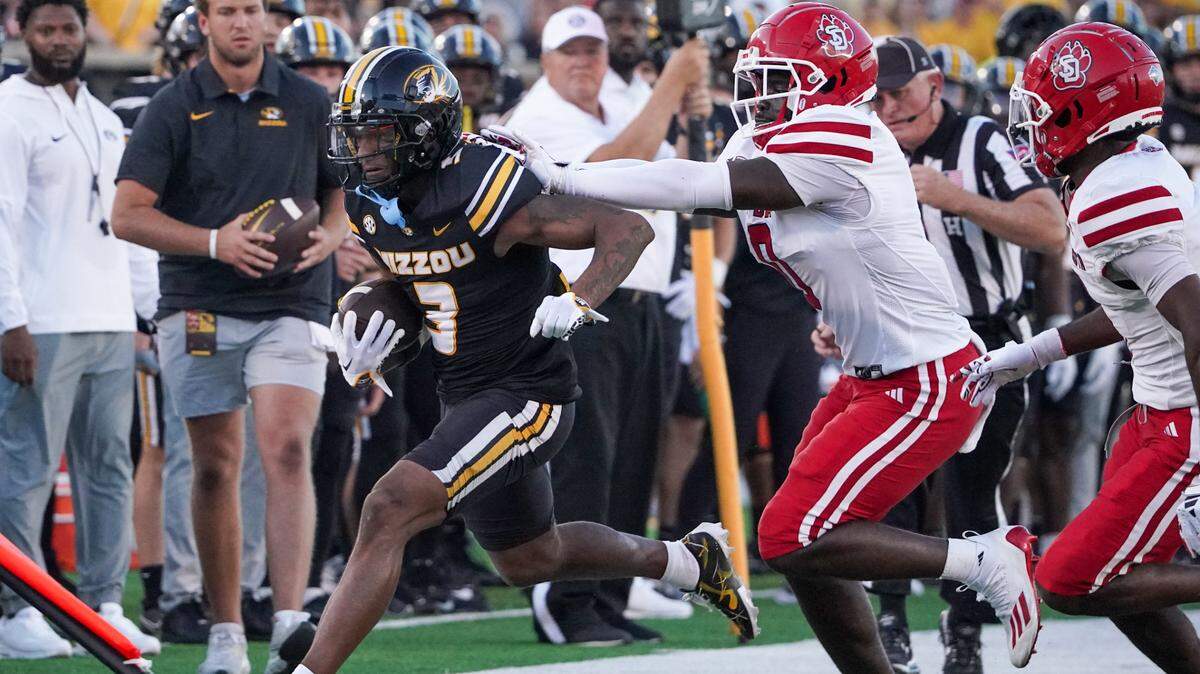 Missouri Tigers wide receiver Luther Burden III (No. 3) runs the ball as South Dakota Coyotes linebacker Jonathan Joanis gives chase during the first half of Thursday night’s season-opening game at Faurot Field in Columbia.
