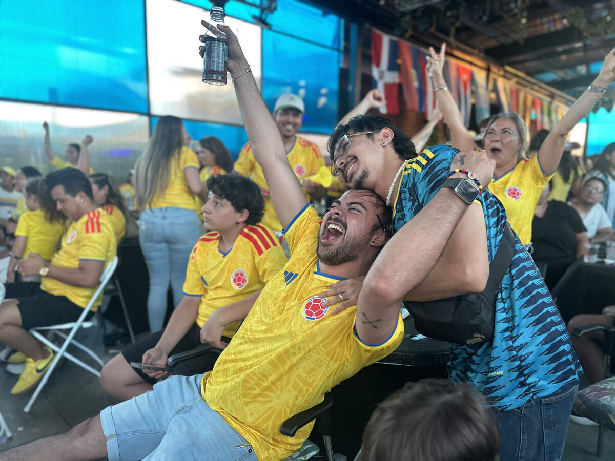 Two Colombia fans embrace after Colombia scores a goal against Portugal on June 26, though the goal was later called offsides.