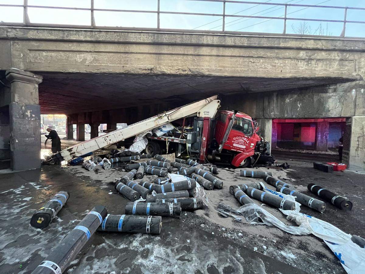 A semi hauling roofing materials struck the infamous, low-clearance Independence Avenue “truck-eating” bridge in Kansas City, spilling supplies Monday morning in Kansas City. The driver suffered non-life-threatening injuries to his hand.