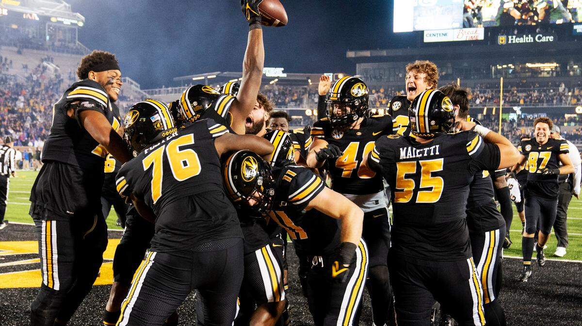 The Missouri football team swarms Missouri tight end Daniel Parker Jr. after he scored on a two-point conversion to defeat Florida during overtime of an NCAA college football game Saturday, Nov. 20, 2021, in Columbia, Mo. (AP Photo/L.G. Patterson)