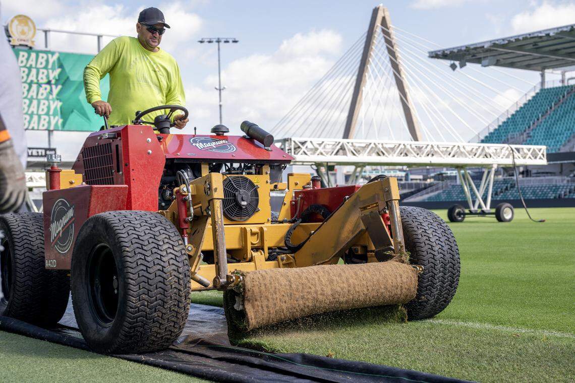 A Briggs Traditional Turf Farm crew member operates a machine laying sod over artificial turf to convert the field for rugby at CPKC Stadium on Tuesday, April 14, 2026, in Kansas City.