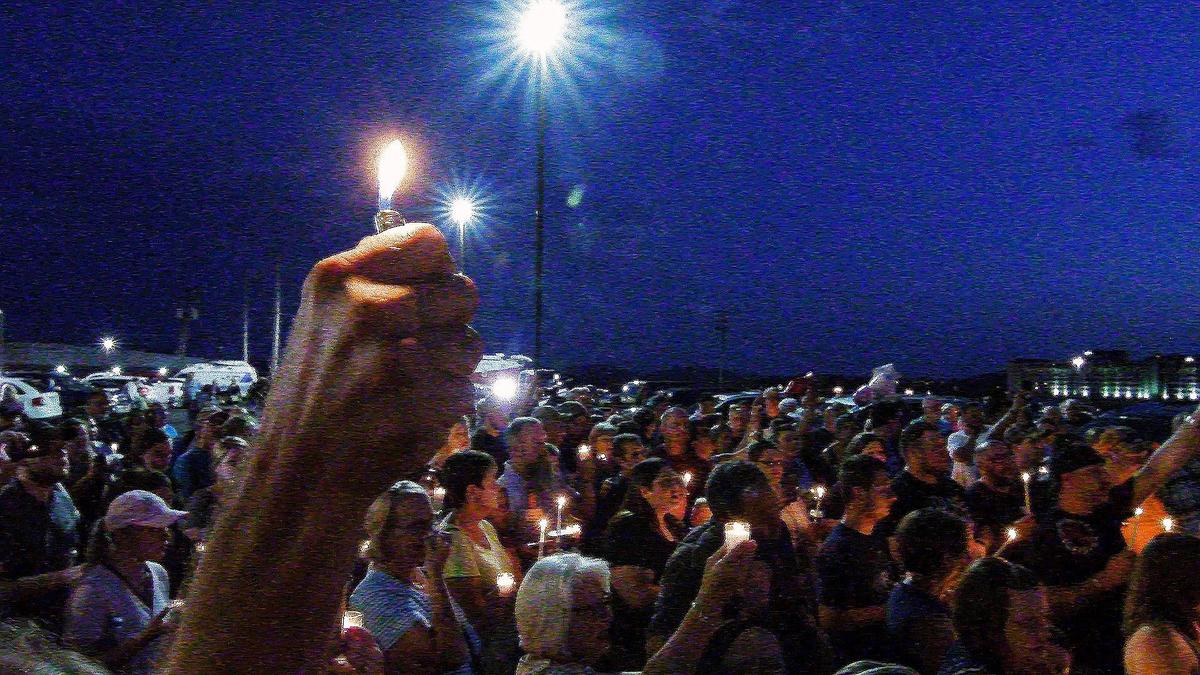 Mourners gather in the parking lot of the Ride the Ducks offices in Branson, Missouri, during Friday's July 20, 2018, candlelight vigil for the victims of the Branson duck boat tragedy at Table Rock Lake.