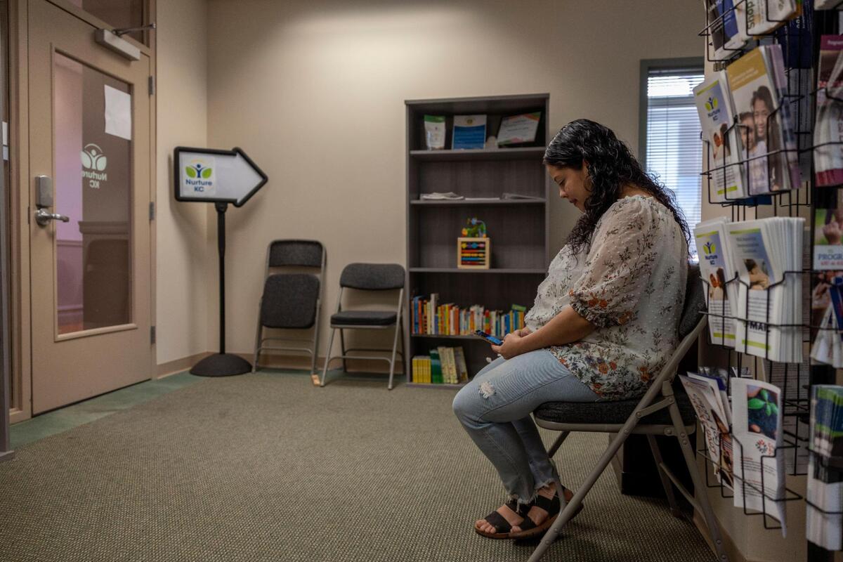 Fabiola Irias, who is due with a baby girl in December, waits for a taxi to take her home from an appointment with a community health worker at Nurture KC. The nonprofit supports pregnant parents across parts of the metro with the highest infant mortality rates.