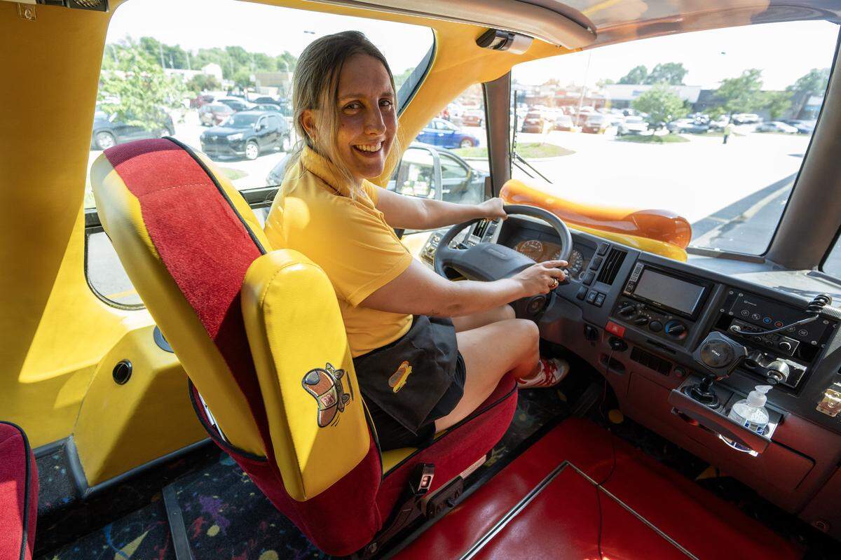 Oscar Mayer Hotdogger Reana Sinclair, known as RelishRaena, sits for a portrait on the driver's side of the Wienermobile during its visit to a local Hy-Vee on Friday, Aug. 8, 2025, in Lee's Summit.