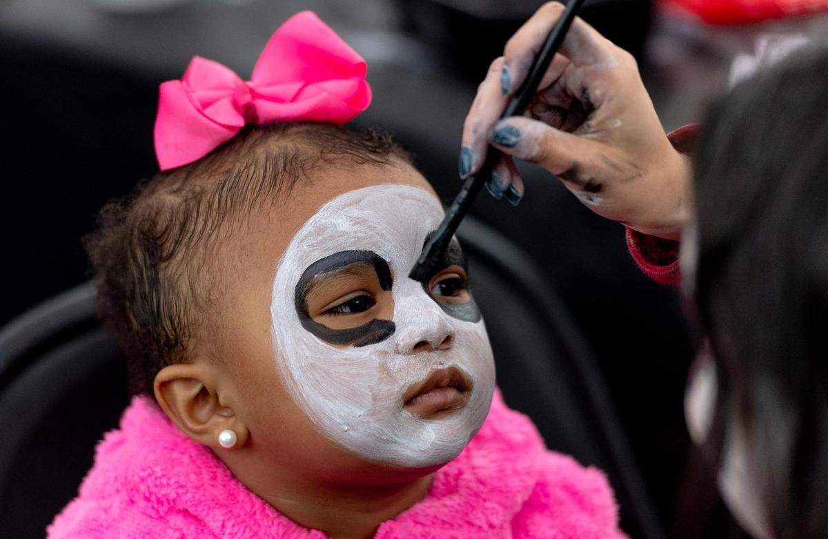 Daenerys Funches, 2, gets her face painted during the Dia de los Muertos event hosted by the Central Avenue Betterment Association on Saturday in Kansas City, Kan.