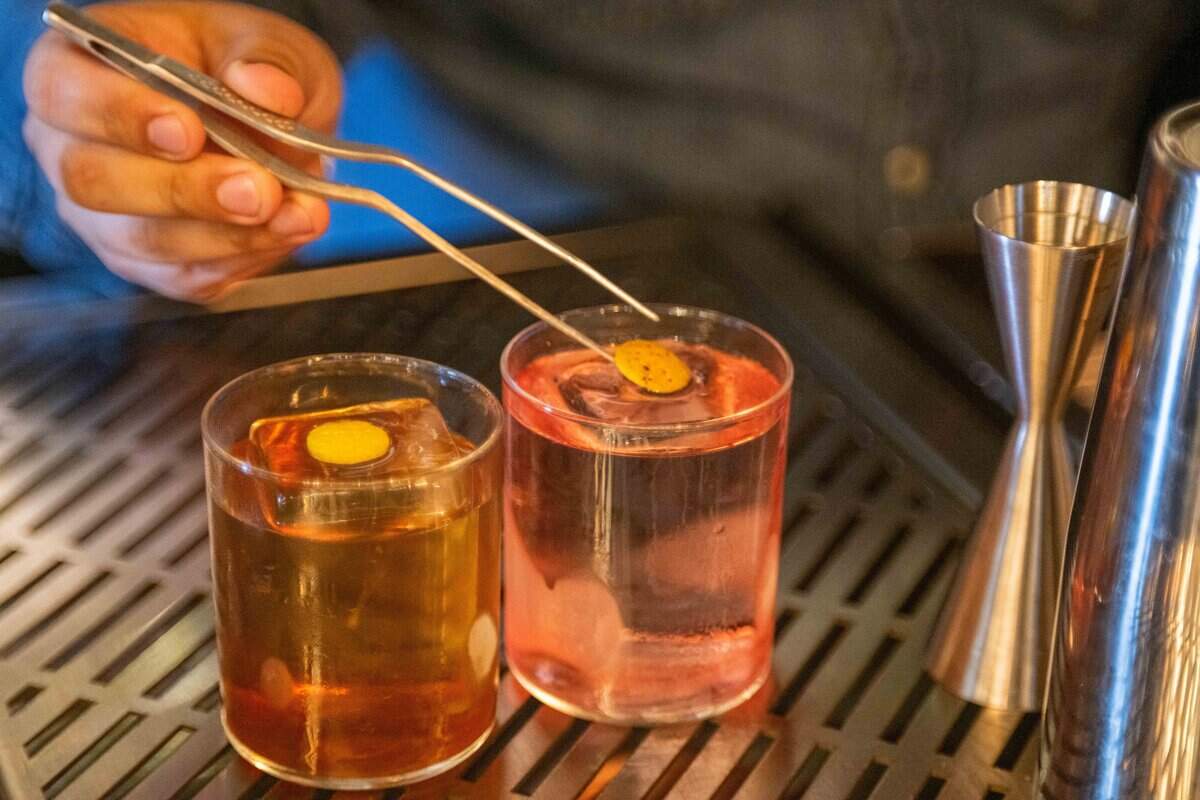 Gun For Hire and Takeoff, two signature drinks at Neat, a new bar concept opening in Lenexa, mixes two of his signature drinks on Thursday, July 9, 2026. Founder Benjamin Davalos created the drink menu based on life experiences and stories.