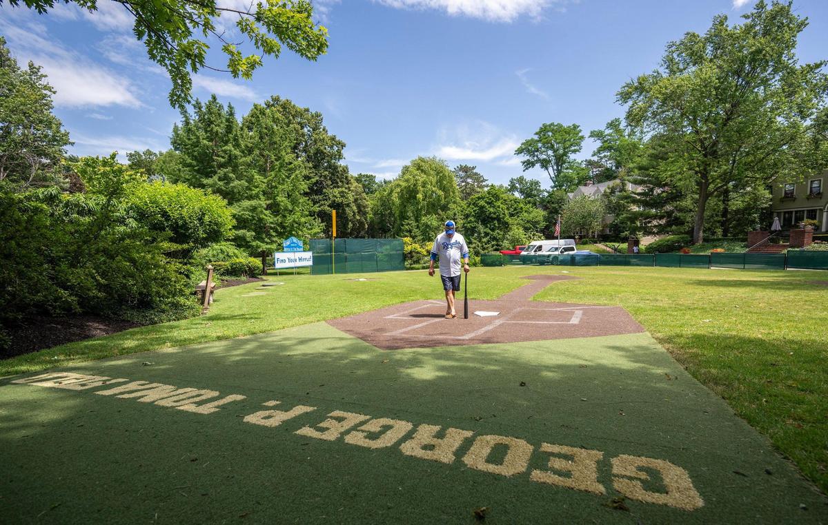 Joe Ungashick stands at home plate at The Hollow, his front yard wiffle ball “stadium,” whose George P. Toma field had been tended by Toma, himself, the famed groundskeeper for the Kansas City Royals and Chiefs.