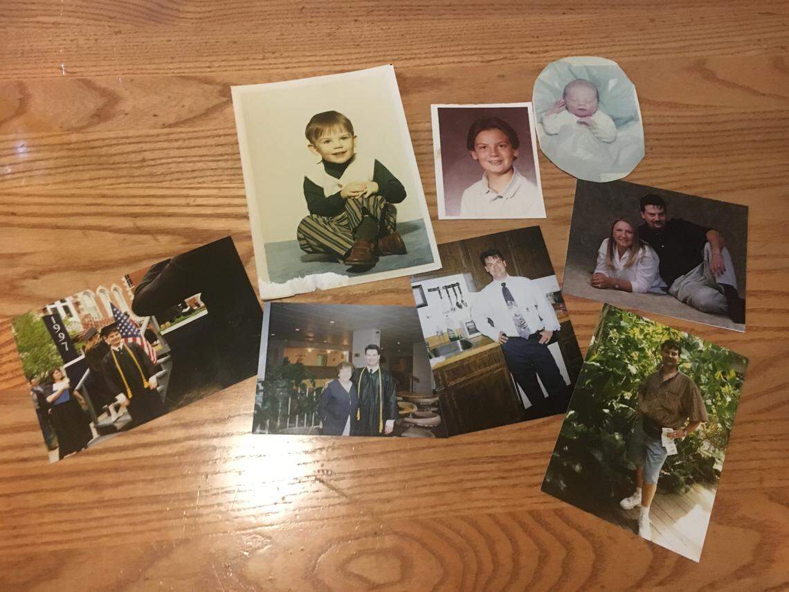 Past photos of Todd McGraw are laid out on a table during a memorial in Lee’s Summit on Sept. 19, 2019. McGraw, 50, was fatally shot in his home in July.