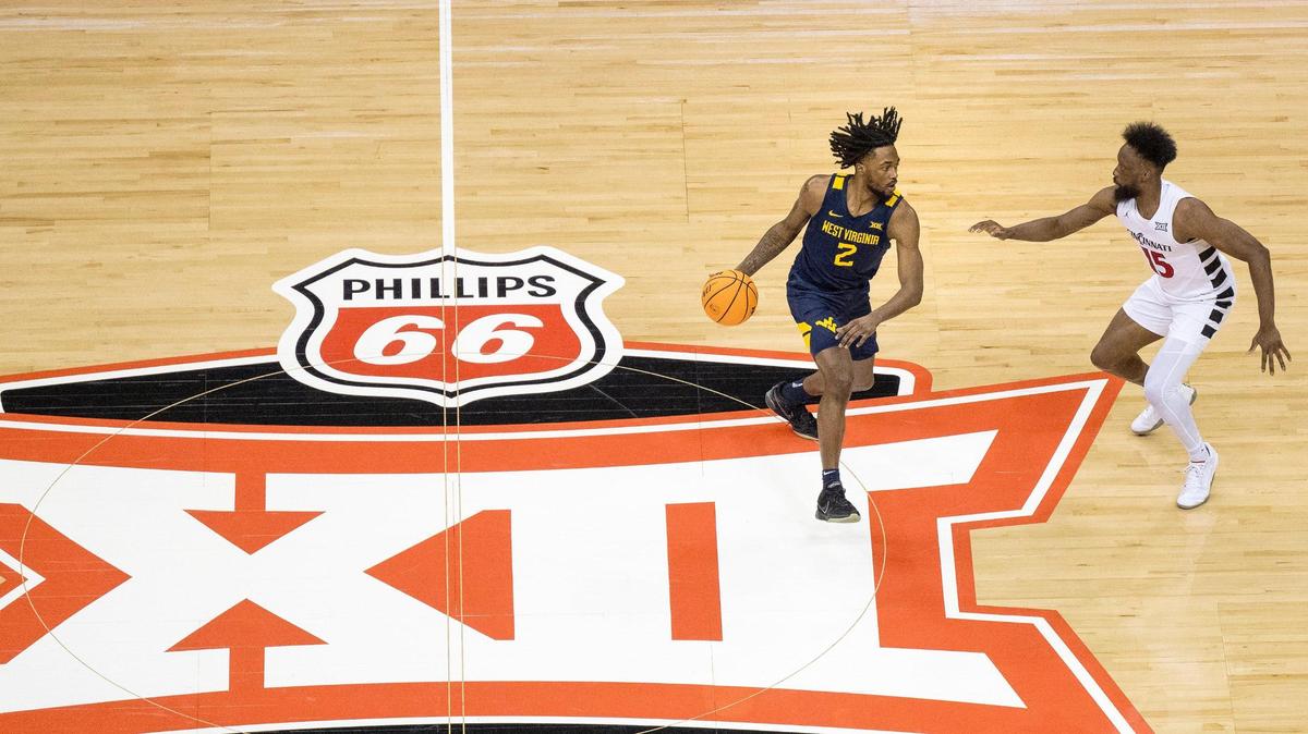 West Virginia Mountaineers guard Kobe Johnson (2) dribbles the ball as Cincinnati Bearcats guard John Newman III (15) defends during the Big 12 basketball tournament at T-Mobile Center on Tuesday, March 12, 2024, in Kansas City.