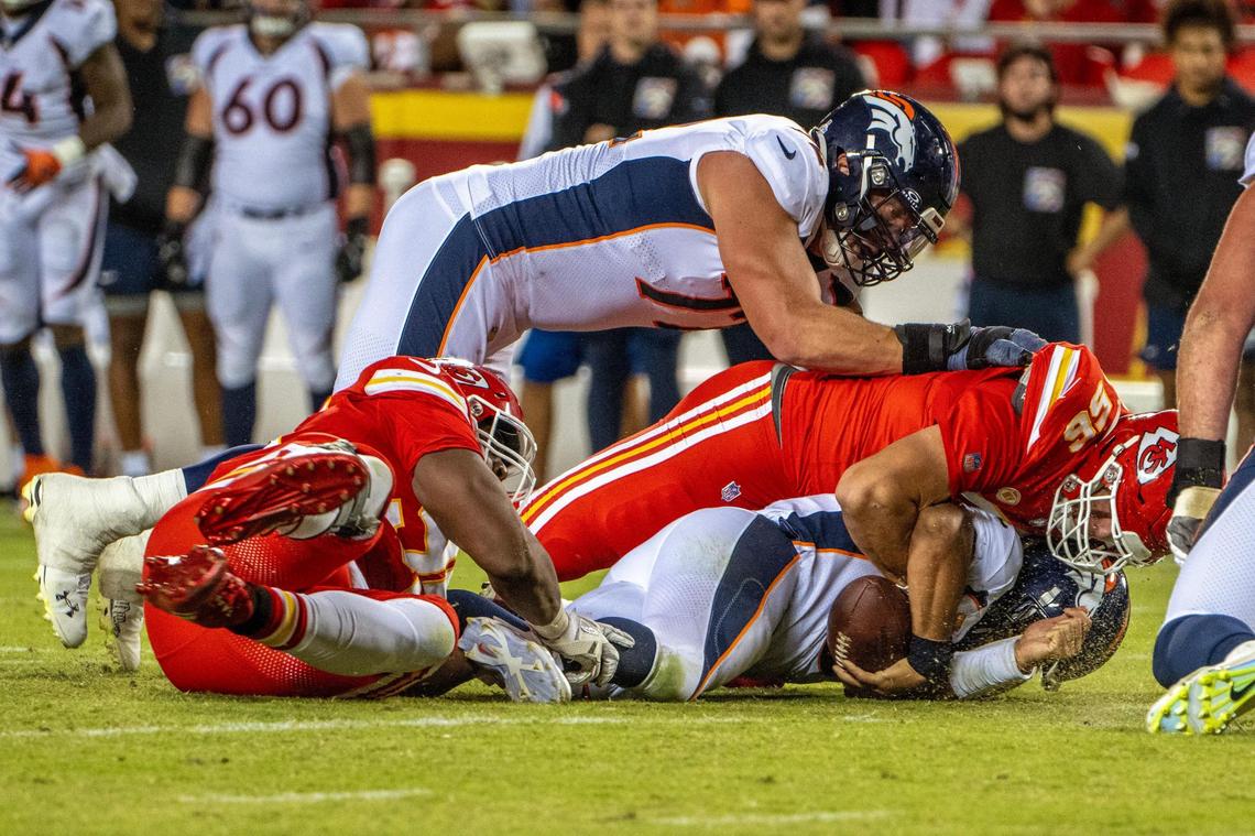 Kansas City Chiefs defensive tackle Chris Jones (95) and defensive end George Karlaftis (56) tackle Denver Broncos quarterback Russell Wilson (3) during a game against the Denver Broncos at GEHA Field at Arrowhead Stadium on Thursday, Oct. 12, 2023, in Kansas City.