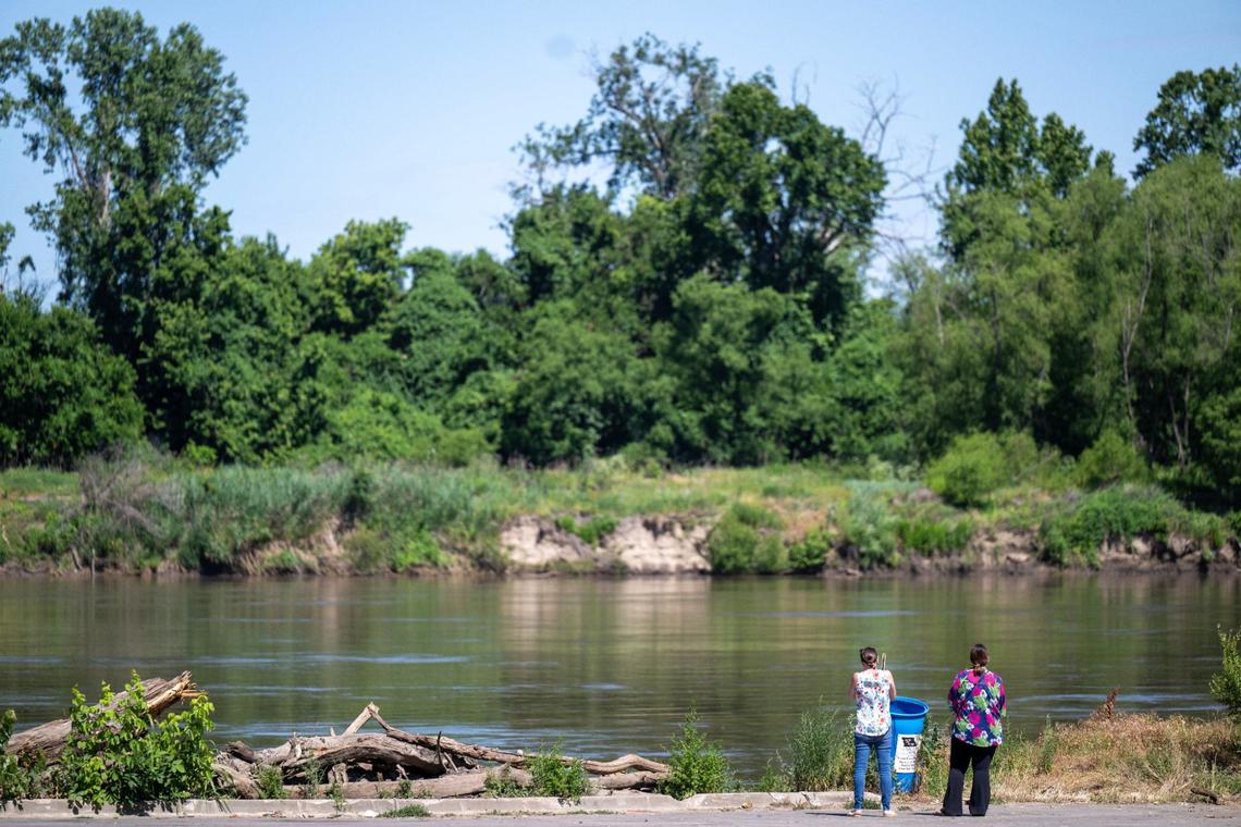 Visitors to Riverfront Park look out over the Missouri River on Friday, June 7, 2024, in Kansas City. 