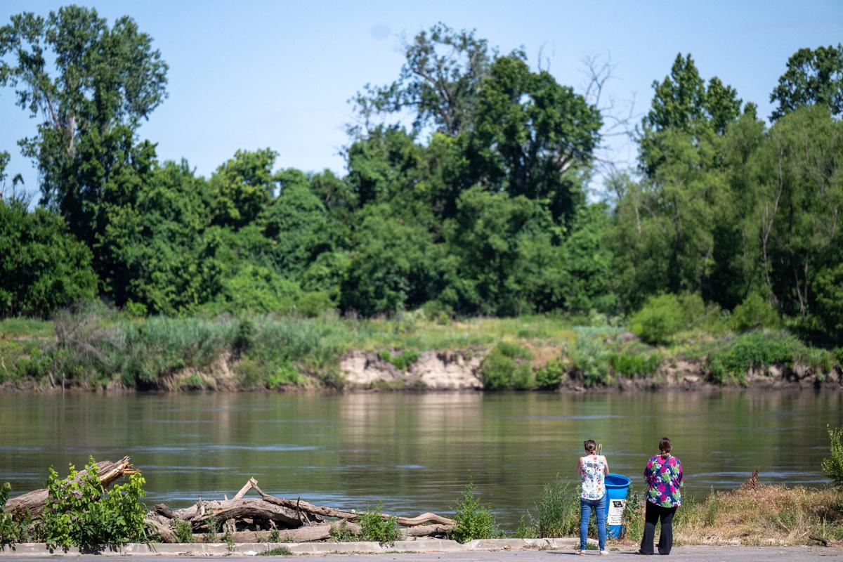 Visitors to Riverfront Park look out over the Missouri River on Friday, June 7, 2024, in Kansas City.