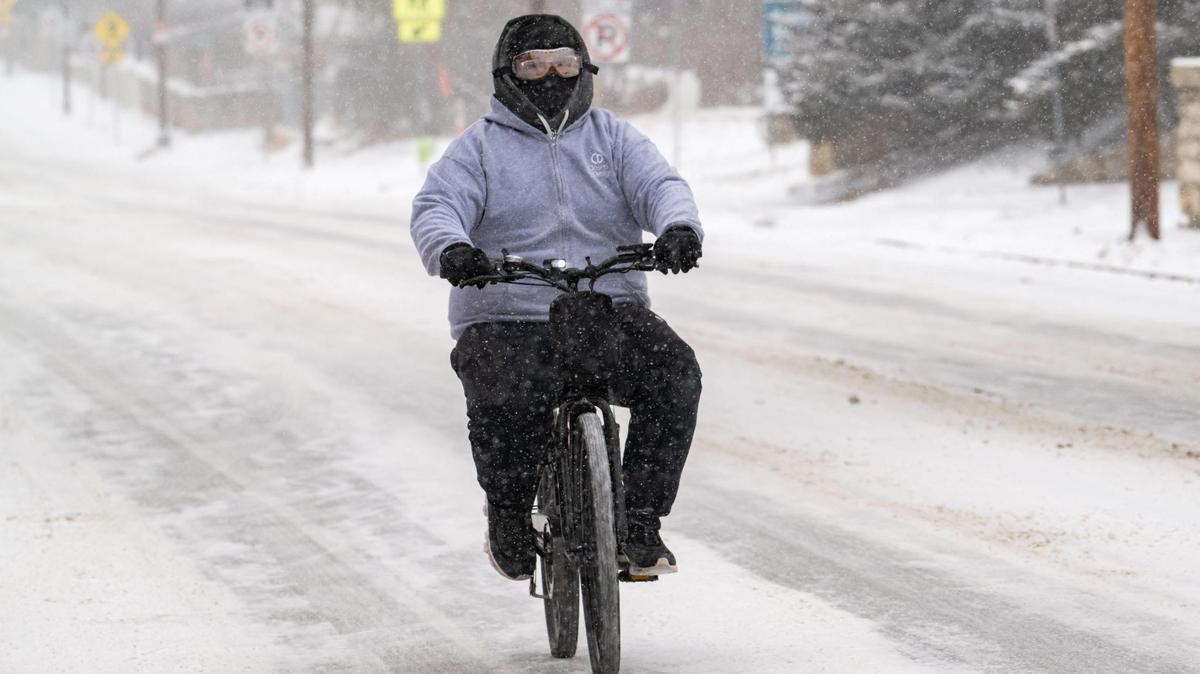 A man rides a motorized bicycle on snow packed roads in Kansas City on Tuesday, Feb. 18, 2025. Subzero temperatures created dangerous conditions during the daytime hours and are supposed to last through Wednesday.
