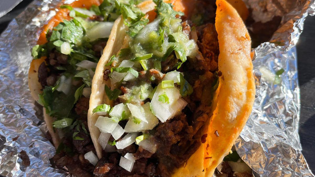 Carne asada tacos are served in a to-go foil cover at Tacos El Guero 100% Michoacanos in Kansas City, Kansas.