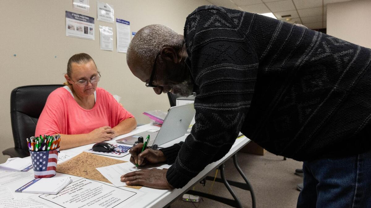 Lonnie Powell from Lee’s Summit fills out forms in order to participate in early voting at the Jackson County Election Board polling station in Independence on Tuesday, Oct. 29. Voters will be assigned to one of 103 locations on Election Day.