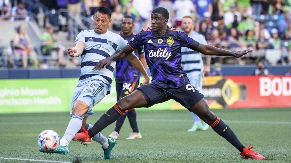 Seattle’s Abdoulaye Cissoko, right, battles Sporting Kansas City’s Roger Espinoza for the ball Sunday night at Lumen Field in Seattle.