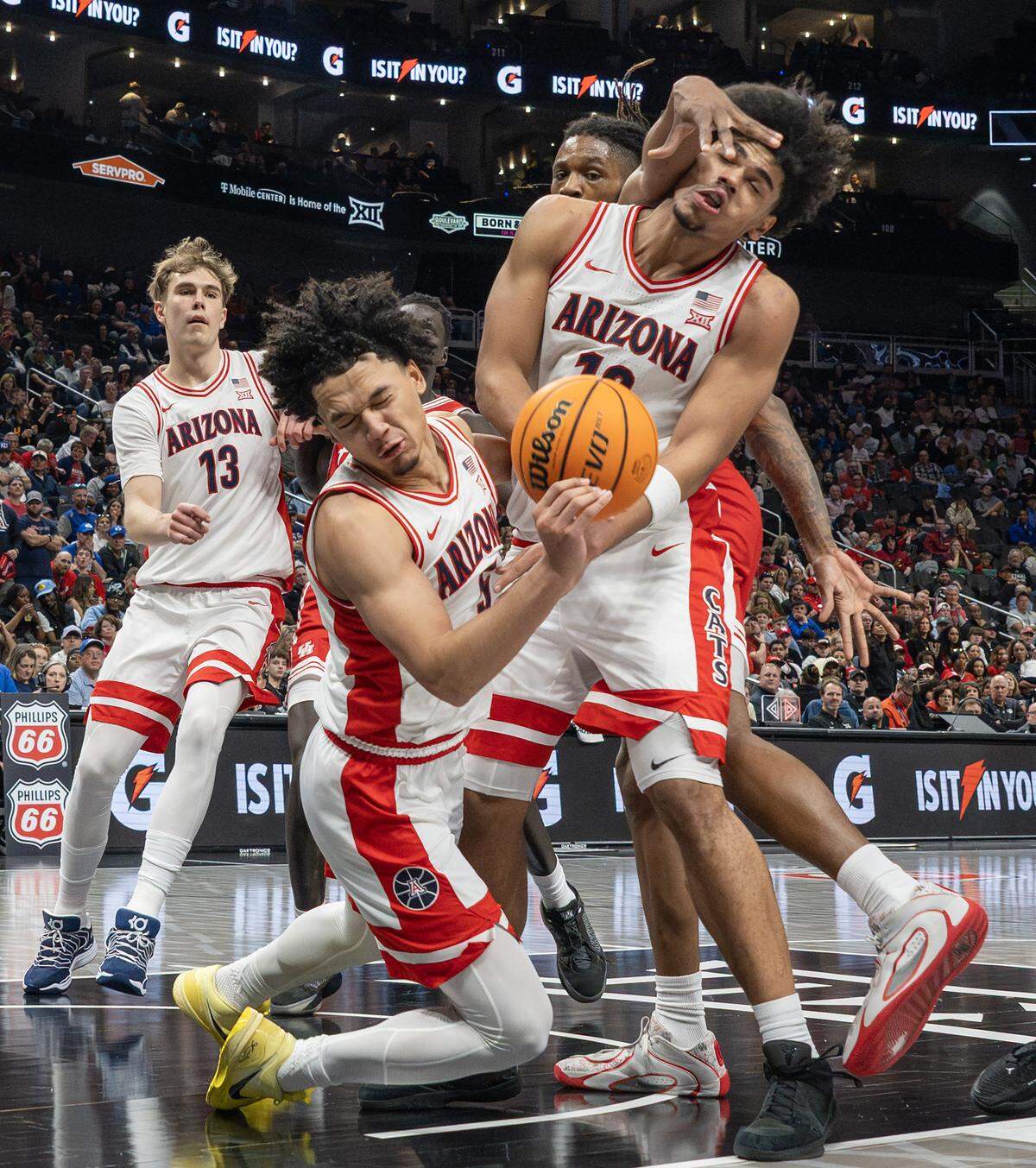 Arizona Wildcats forward Koa Peat (10) is fouled by Houston Cougars forward Joseph Tugler (11) during the second half of the Big 12 Men's Basketball Tournament Championship game at T-Mobile Center on Saturday, March 14, 2026, in Kansas City.