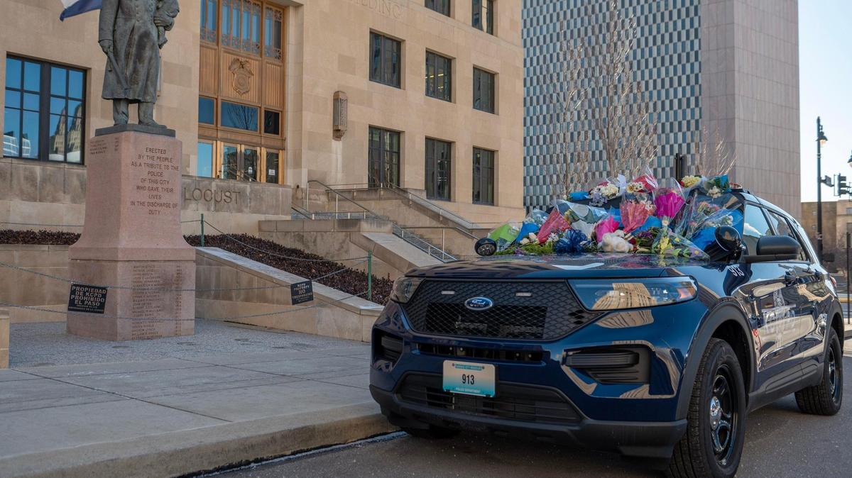 Flowers are seen placed on a Kansas City Police Department patrol car as a memorial for KCPD Officer James Muhlbauer at police headquarters on Friday, Feb. 17, 2023. Muhlbauer and his K-9 police dog Champ were killed in a car crash Wednesday when a vehicle struck their patrol car. A nearby pedestrian also died in the crash.