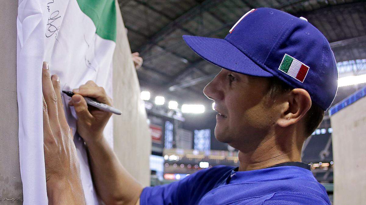 Italy’s Brian Sweeney signs autographs before a World Baseball Classic game against the United States on Saturday, March 9, 2013, in Phoenix.