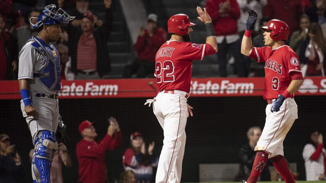 Los Angeles Angels' Ian Kinsler, right, celebrates his two-run home run with Kaleb Cowart, center, as Kansas City Royals catcher Salvador Perez waits during the sixth inning of a baseball game in Anaheim, Calif., Wednesday, June 6, 2018.