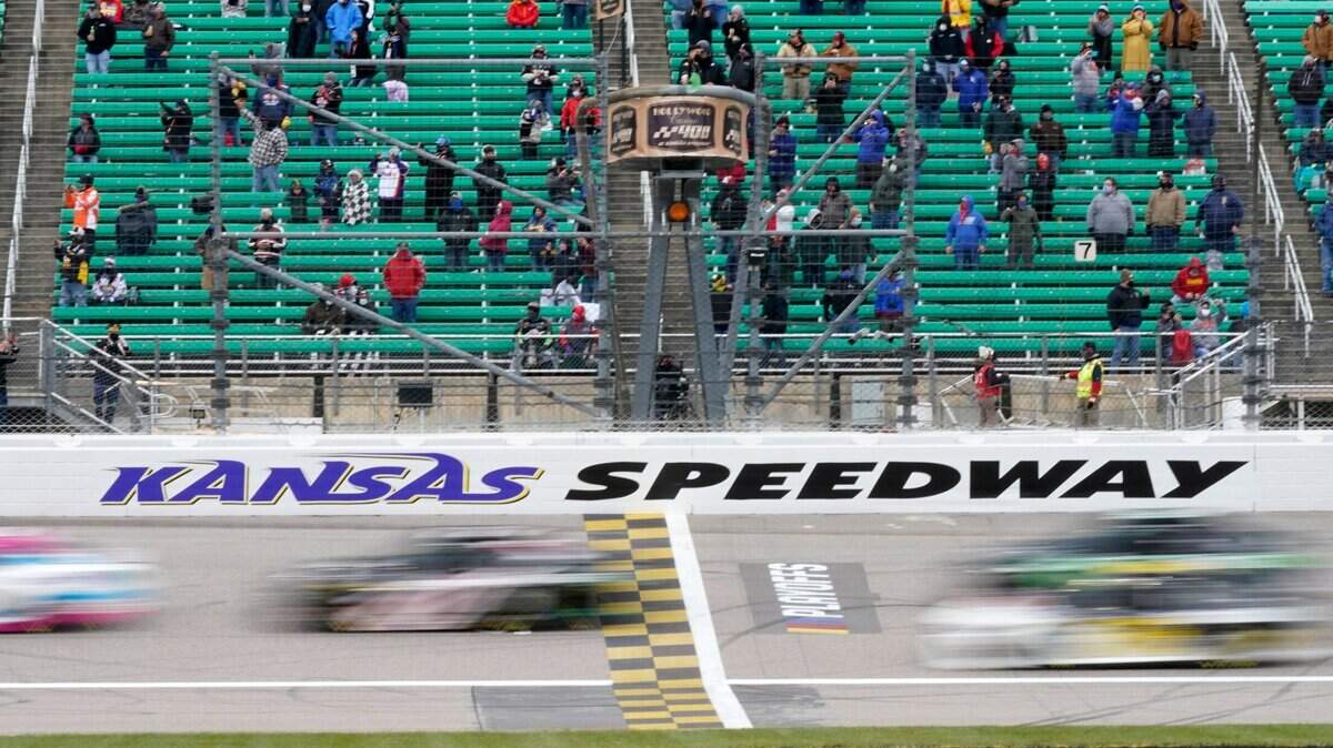A crowd of reduced capacity due to the COVID-19 pandemic watches drivers take the green flag for Sunday’s NASCAR Cup Series race at Kansas Speedway in Kansas City, Kansas.