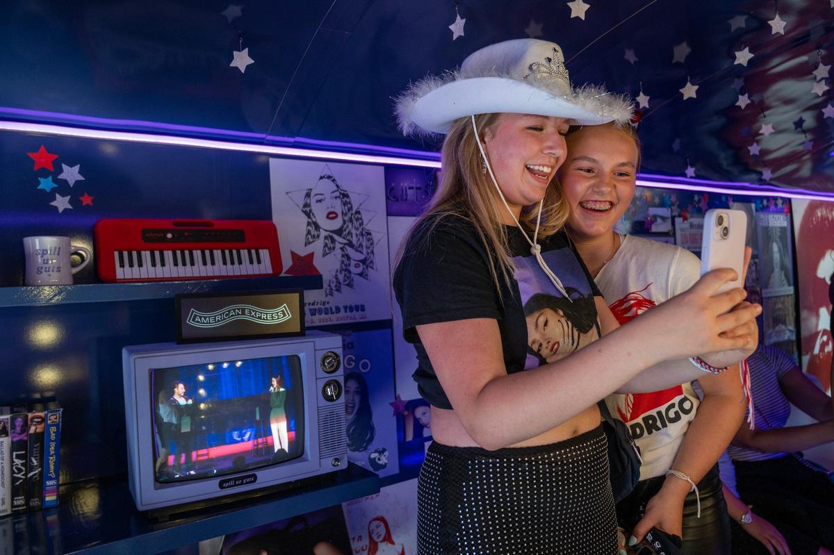 Lindy Shewfelt, left, and Anna Njegovan Rosenberger take photos while visiting an interactive exhibit for the Olivia Rodrigo Guts World Tour concert outside of T-Mobile Center on Friday, July 26, 2024, in Kansas City.