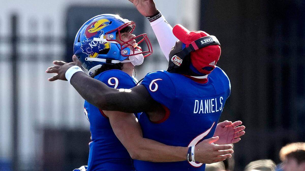 Kansas quarterback Jalon Daniels (6) celebrates with quarterback Jason Bean (9) after Bean ran for a touchdown against Oklahoma State Saturday, Nov. 5, 2022, in Lawrence, Kan.