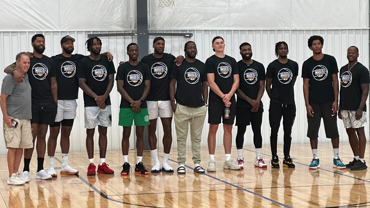 Members of the KU almuni basketball team known as Mass Street pose together in team T-shirts after Sunday’s open practice.