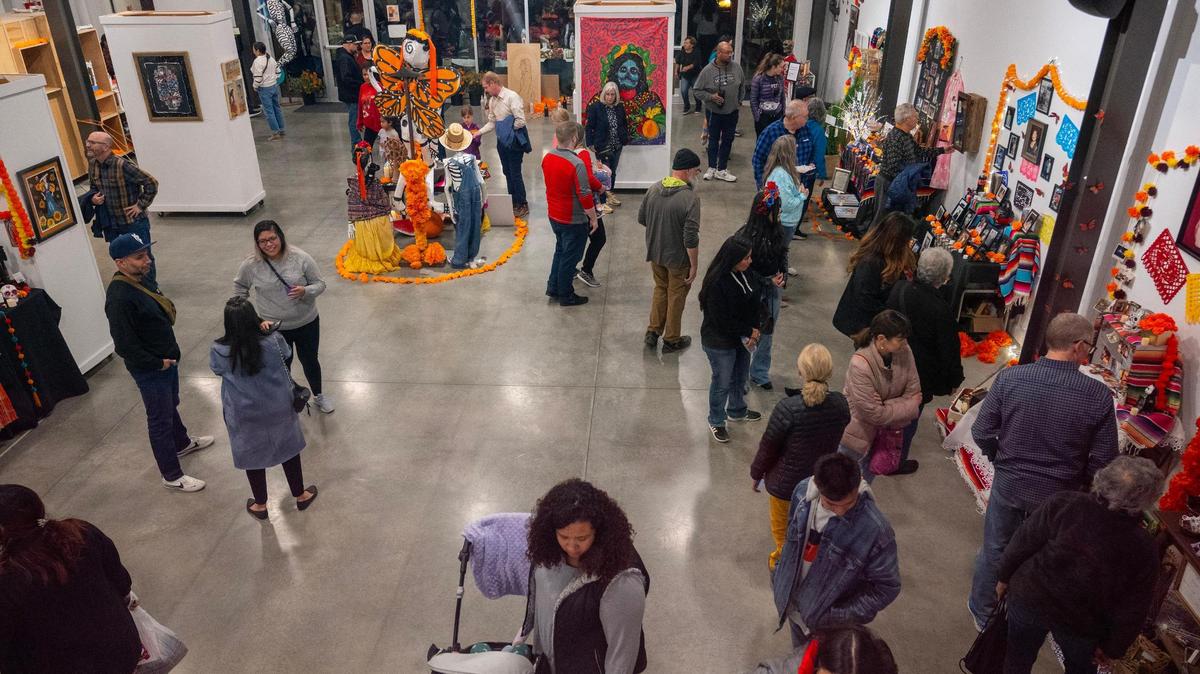 Visitors walk through the Mattie Rhodes Culture Center to view ofrendas during the Dia De Los Muertos festival on Friday, Nov. 3, 2023, in Kansas City.