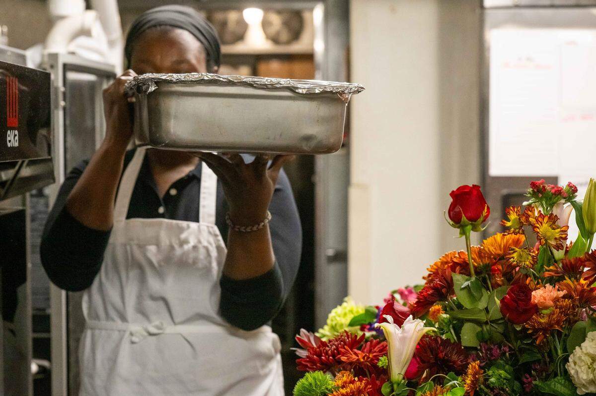 Volunteer Whitney Jones carries a container of food during meal prep at The Prospect KC, a community kitchen, on Thursday, November 6, 2025, in Kansas City. Homeless customers are able to come and eat a hot meal complete with service and a free pantry.