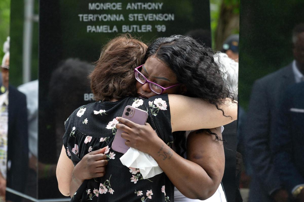 Jennie Anderson, left, and Aishah Coppage embrace during the unveiling of the Children’s Memorial at Hibbs Park on Thursday, May 15, 2025, in Kansas City. The memorial honors children lost to violence between 2001 and 2024, serving as a site for healing, remembrance and a commitment to protecting young people. Both women lost loved ones, including children in their families.