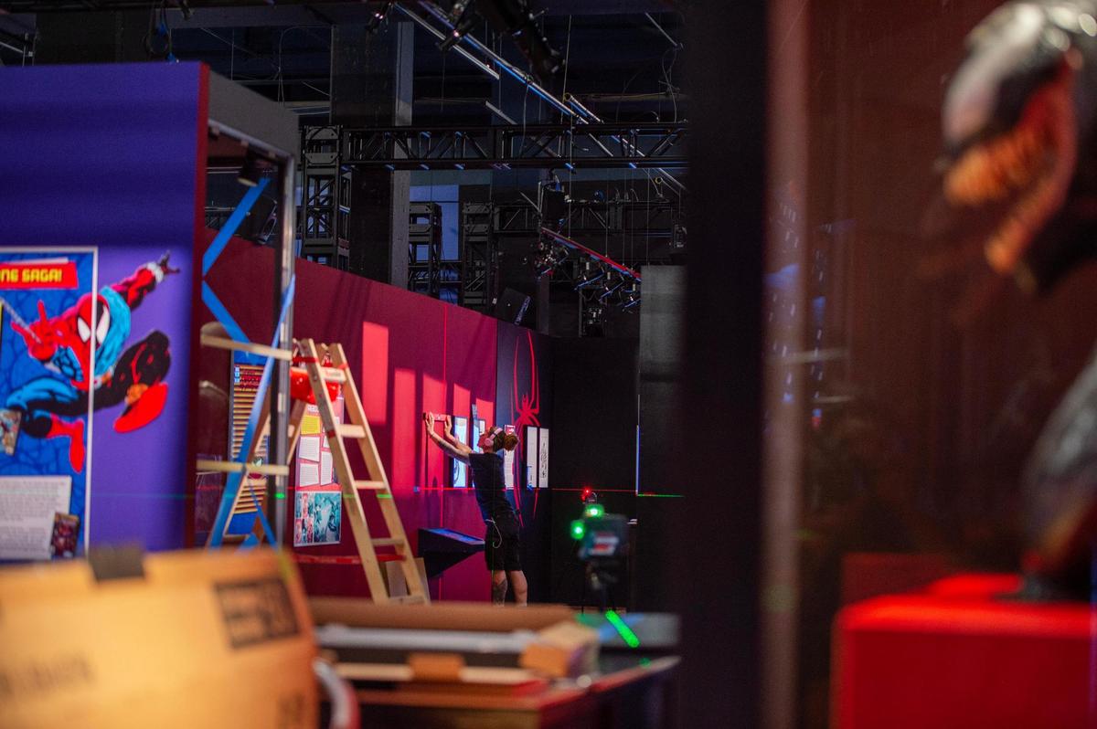 A crew member takes measurements for a picture frame during the “Spider-Man: Beyond Amazing” exhibit set up Monday at Union Station.