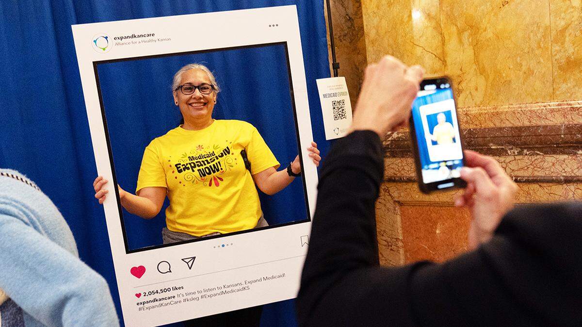Amanda Vega-Mavec, a resident of El Centro, has her photo taken within a frame from Alliance for a Healthy Kansas during a Medicaid expansion rally March 6 in the Kansas State Capitol.