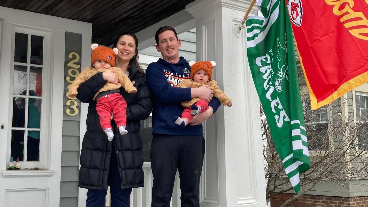 In a show of town spirit, Chiefs and Eagles flags hang from the boyhood home of Travis and Jason Kelce on Coleridge Road in Cleveland Heights, Ohio. Megan Ansbro and husband Levi Heacock, seen with twin sons Henry, left, and Hugo, moved there in August.
